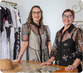 Foto mostrando duas clientes do sistema de gestão de lojas Nex em pé em sua loja de roupas